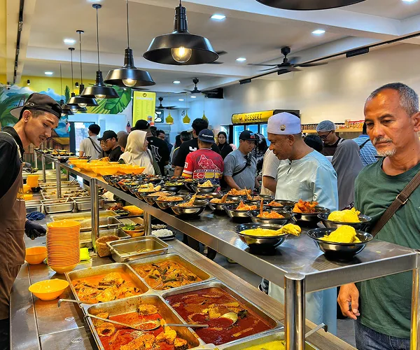 Pelanggan beratur di sepanjang kaunter lauk Mak Kimbong pada waktu makan tengah hari