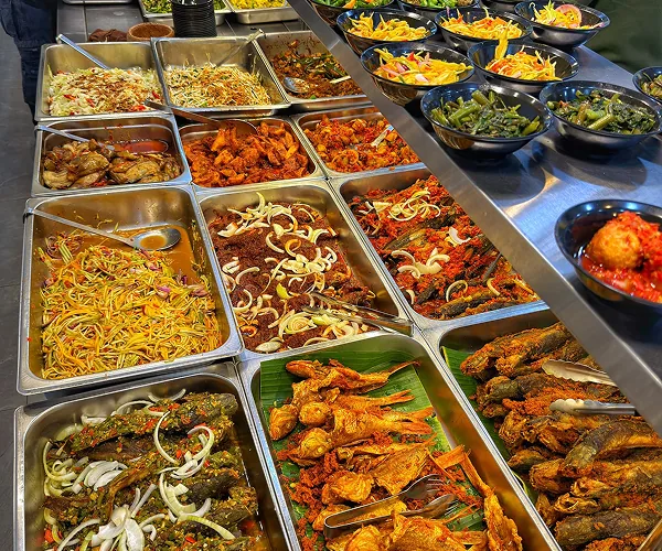 Dulang-dulang lauk tengah hari di kaunter Restoran Mak Kimbong