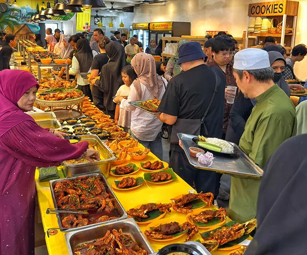 Kaunter kuning Restoran Mak Kimbong dengan ikan bakar yang dah siap dibakar di atas daun pisang, dan pelanggan memilih lauk dengan dulang
