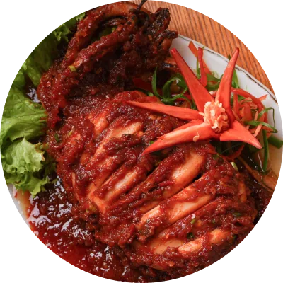 Sotong bakar bersalut sambal merah pekat, dihias bunga lobak merah dan daun salad, di Restoran Mak Kimbong